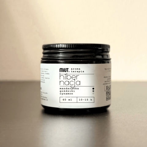 Świeca do aromaterapii HIBERNACJA 60 g MiUT w szklanym słoiku, minimalistyczna aranżacja na jasnym tle